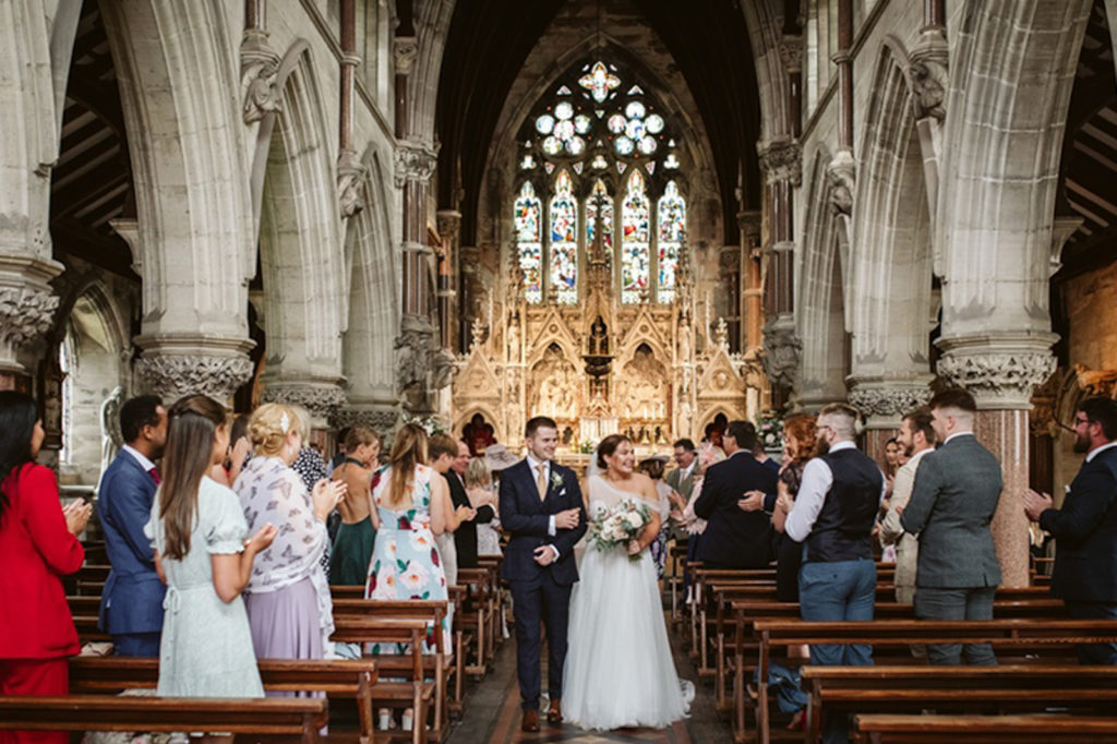 Documentary photo of couple exiting their ceremony at Rudding Park chapel