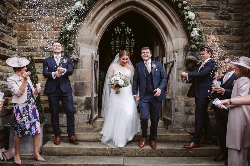 Confetti moment outside Rudding Park after summer wedding ceremony