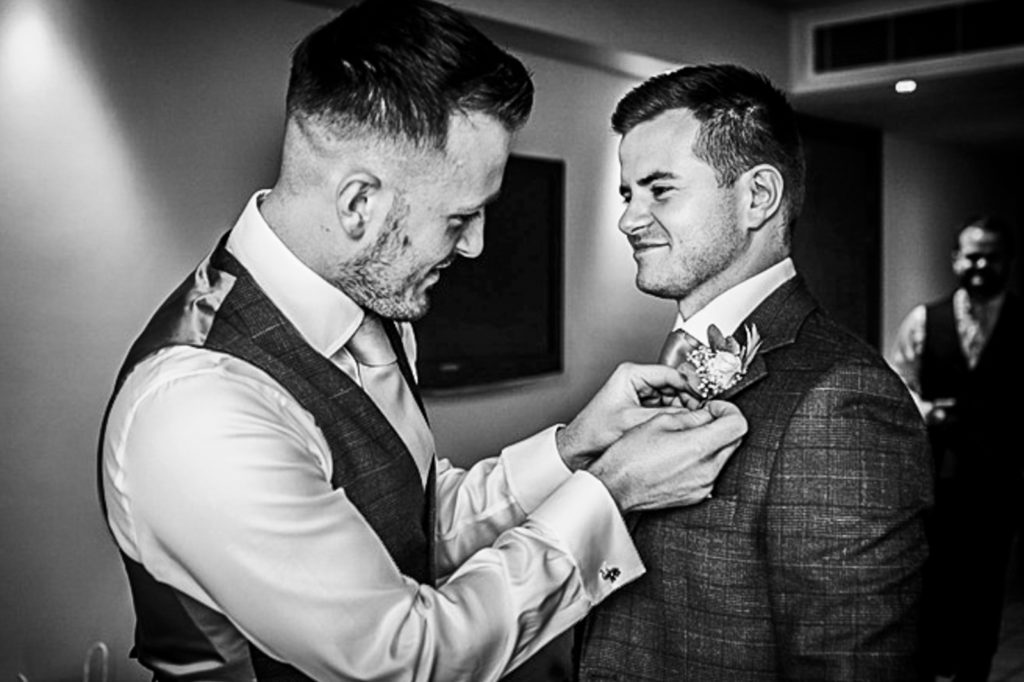 Groom getting ready at Rudding Park surrounded by friends on wedding morning