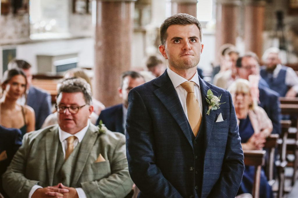 A nervous groom waiting for his Bride in the chapel at RuddingPark