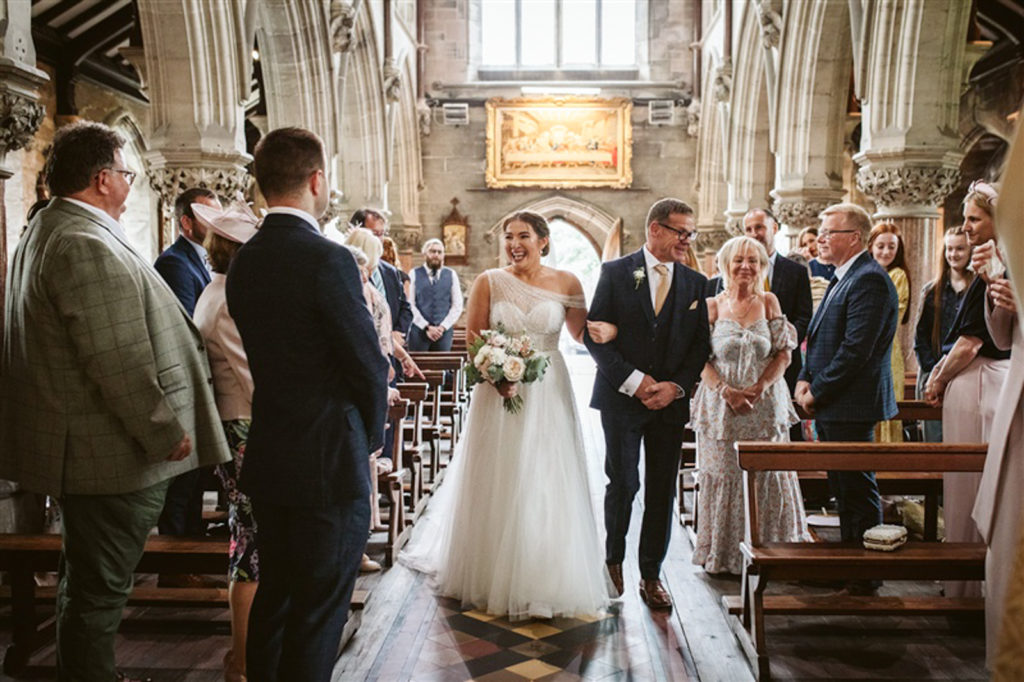 Bride walking down the aisle in Rudding Park chapel