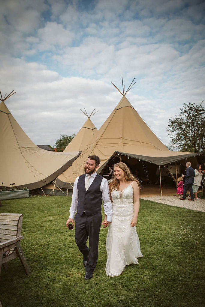 Bride and groom walking through fields at Skipbridge wedding venue Yorkshire
