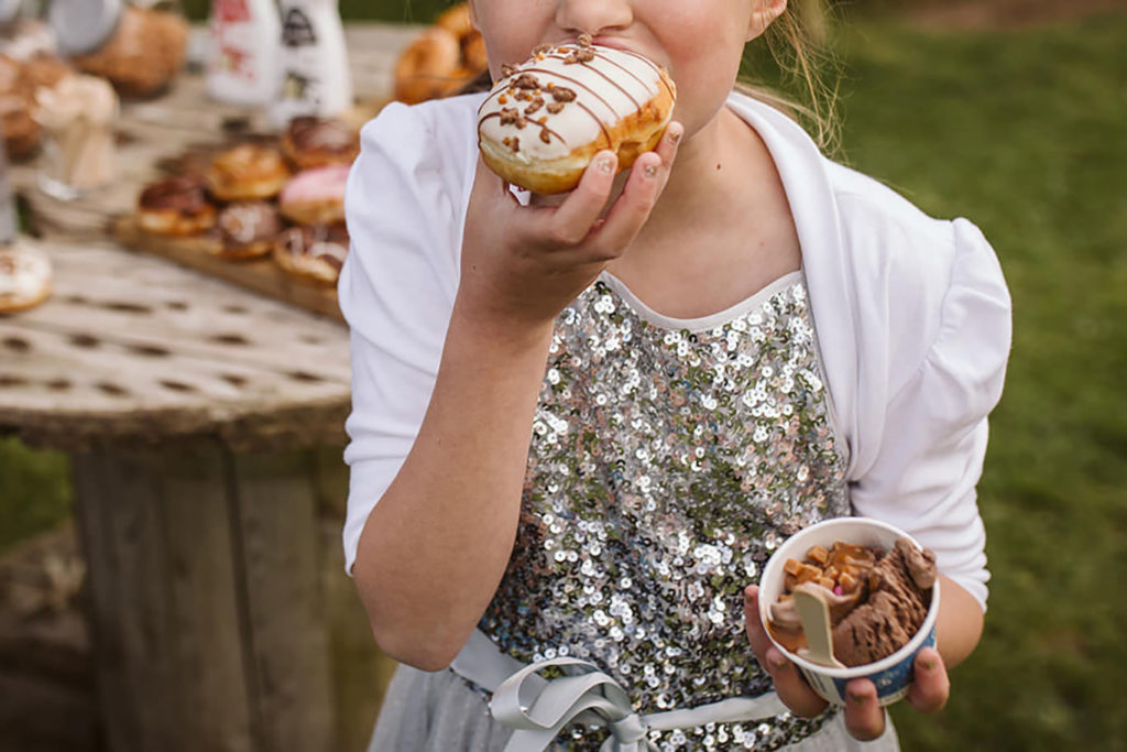 Pudding of doughnuts and ice cream being devoured by a small wedding guest