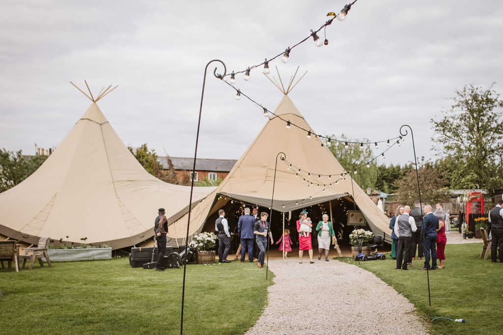 Wedding guests mingling outdoors at Yorkshire tipi wedding venue
