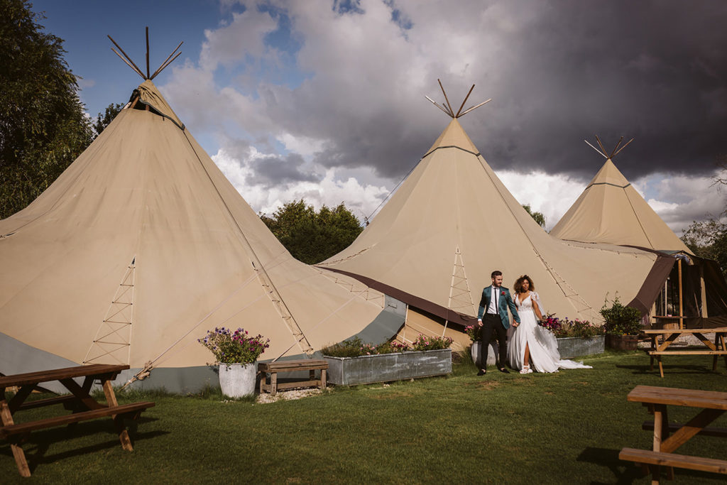 Bride and groom in bold autumn wedding styling at tipi venue