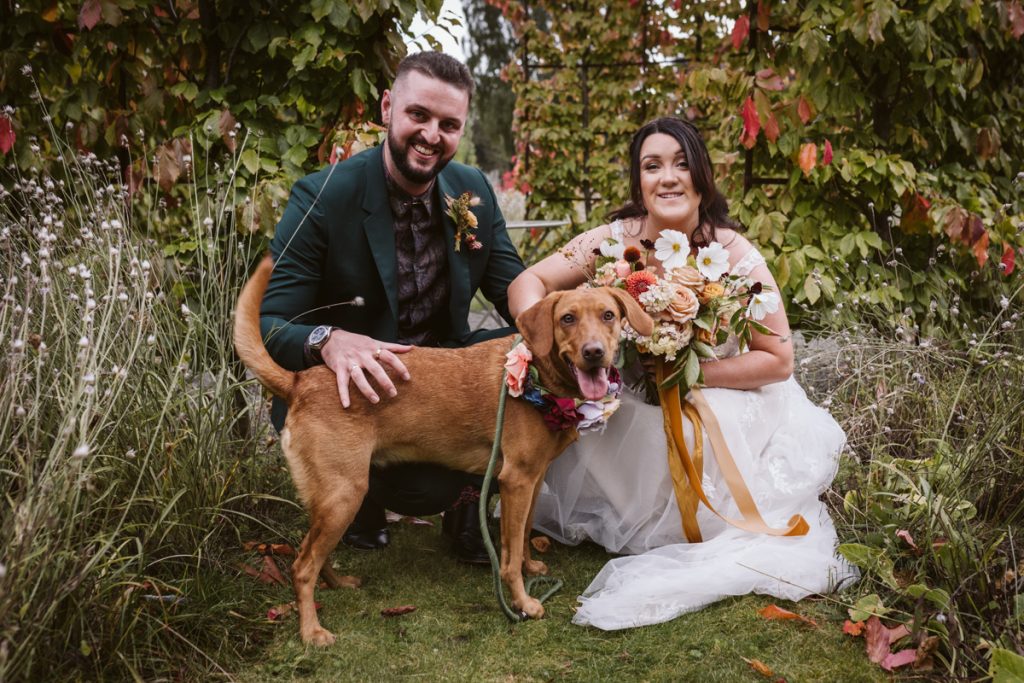 A portrait of the Bride and Groom with their dog in the Walled Garden of the Fig House, Middleton Lodge