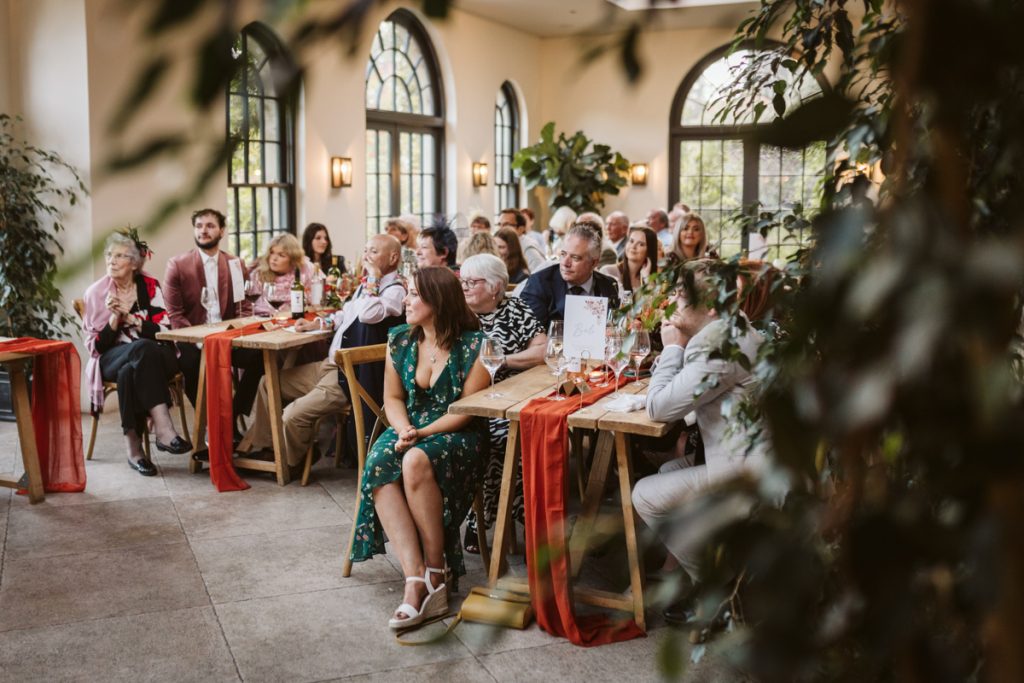 Guests listen intently during the speeches at this beautiful fig house wedding