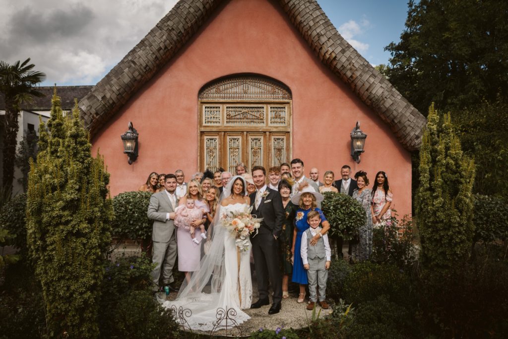 Group photo in front of the pink exterior of Le Petit Chateau, Northumberland