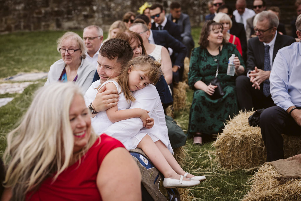 A cute moment between guests during the ceremony at East Keswick Village Hall