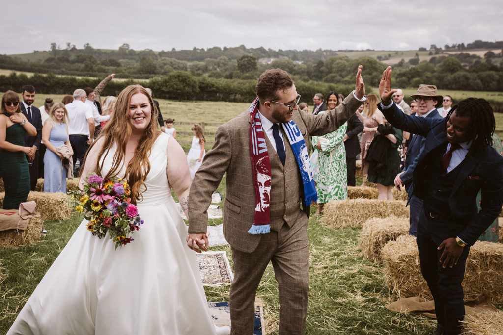 A high five as the bride and groom exit their wedding ceremony at East Keswick Village Hall