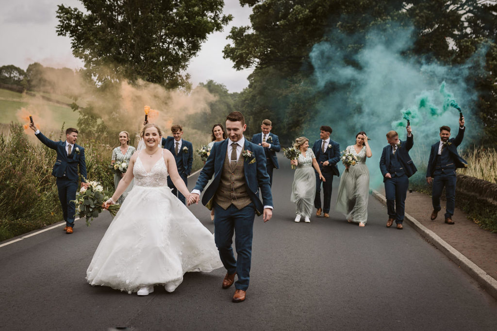 North Yorkshire Wedding Photography - Bride, groom and bridal party taking a walk with smoke grenades