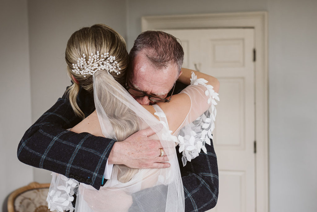 The bride and her father share an emotional embrace at Newton Hall