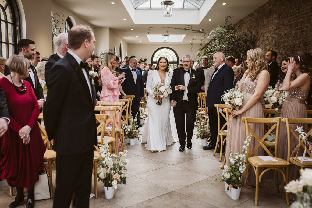 The Bride and her father arriving to the wedding ceremony at the Fig House, Middleton Lodge.