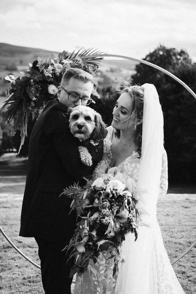 The happy couple pose with their beloved Cavapoo