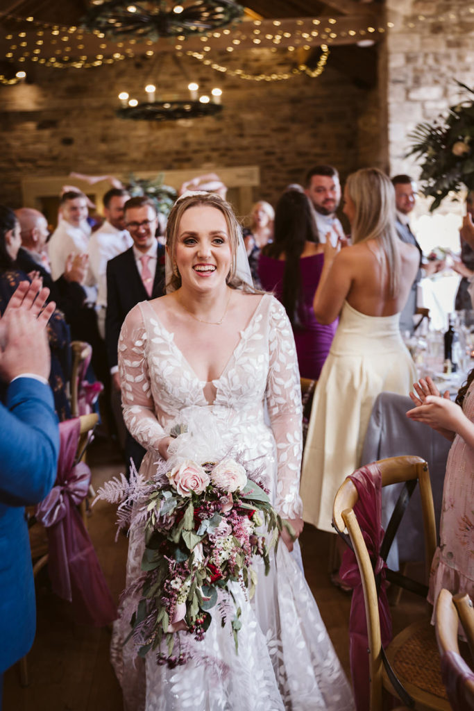 A happy bride makes her entrance to the Wedding Breakfast