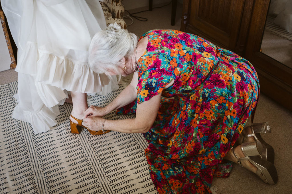 The mother of the bride helping her daughter get dressed