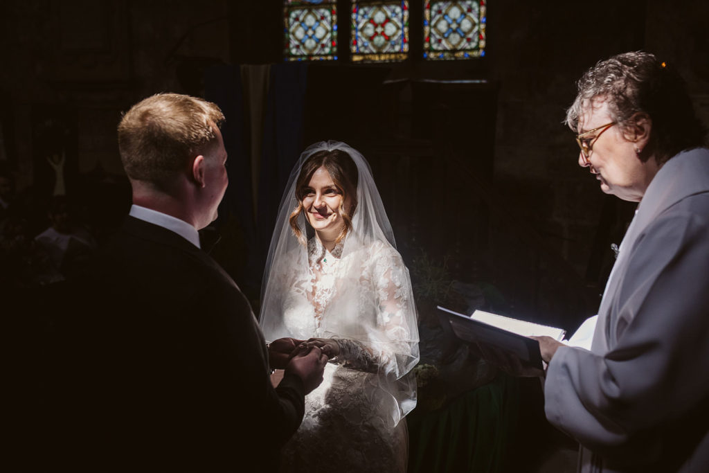 Light falling beautifully onto the bride as she says her vows