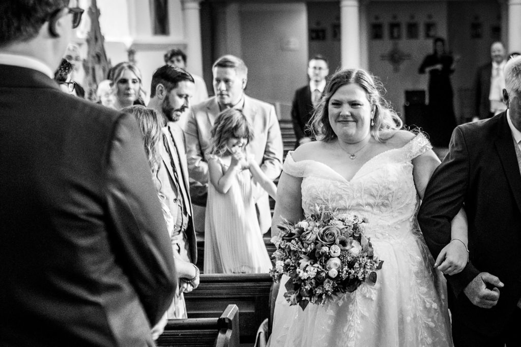 bride walking into Hazlewood Castle chapel wedding ceremony