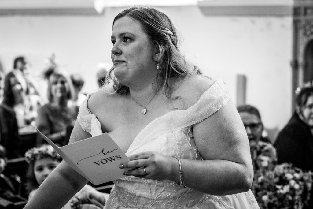 bride reacting during vows in Hazlewood Castle chapel
