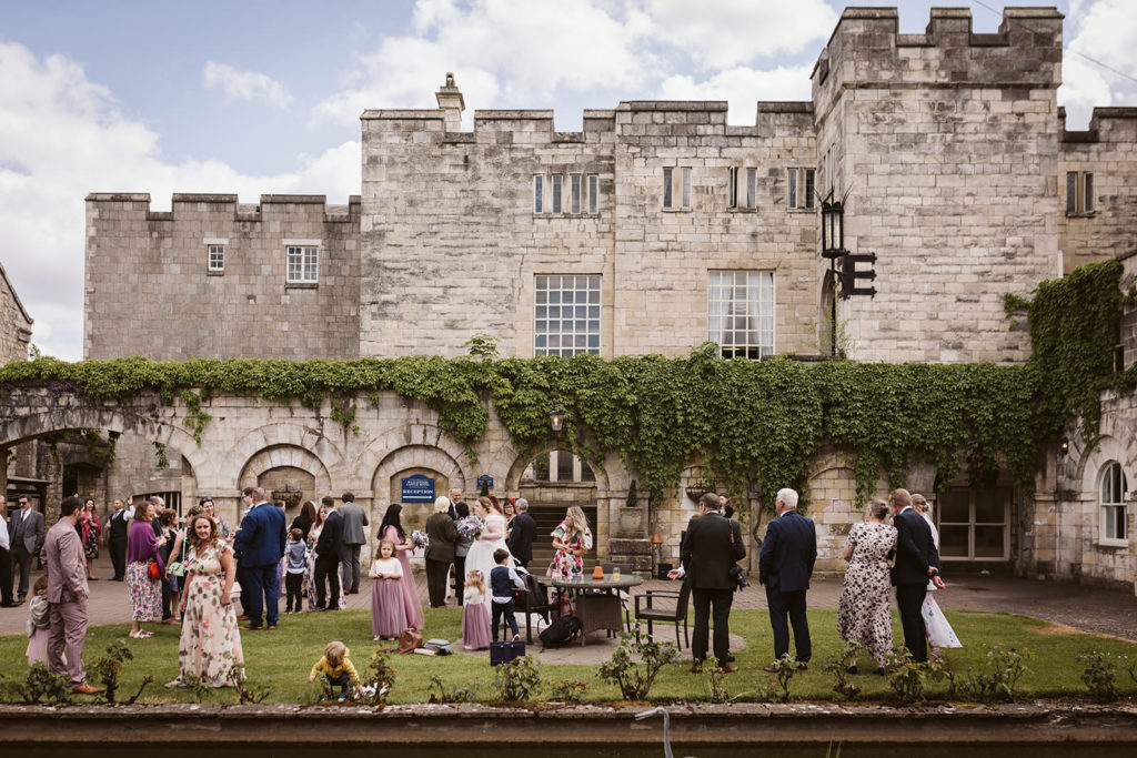 Guests mingling during drinks reception at castle wedding venue