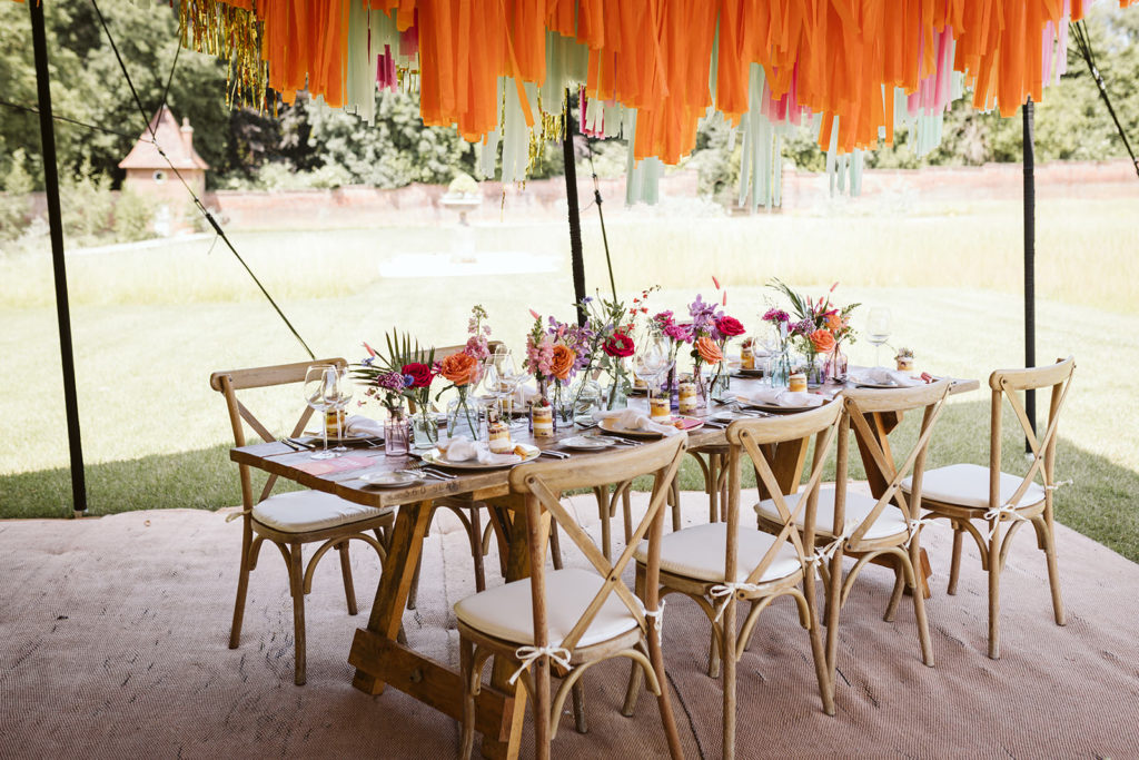 Bold colourful wedding tablescape in marquee setting