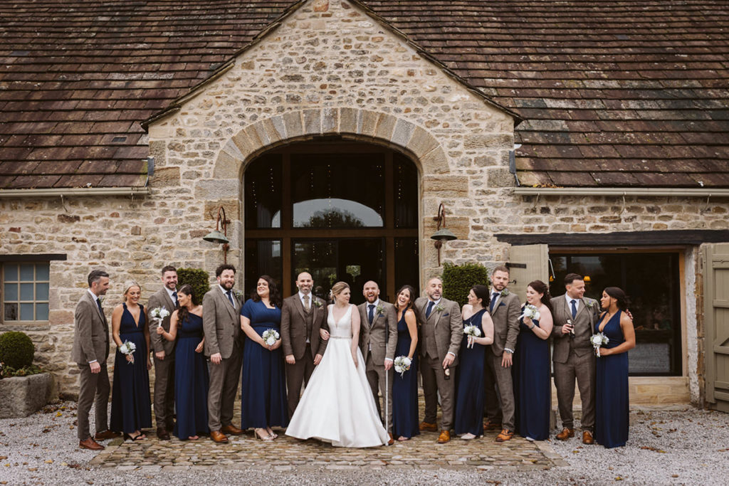 Guests laughing during group shots in a North Yorkshire barn wedding