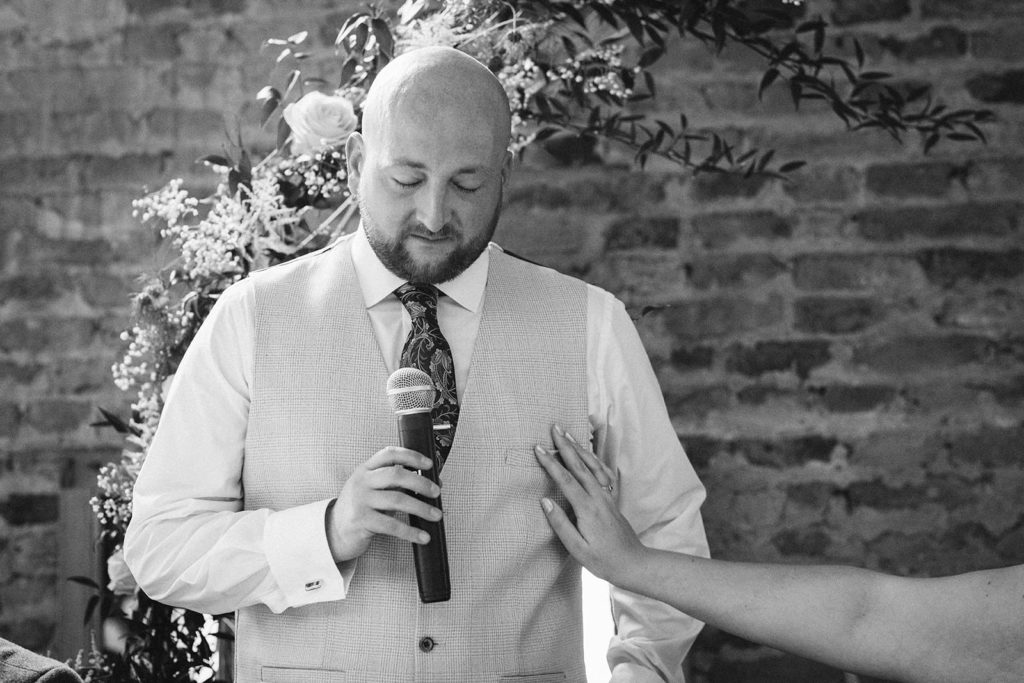 An emotional groom comforted by his new wife