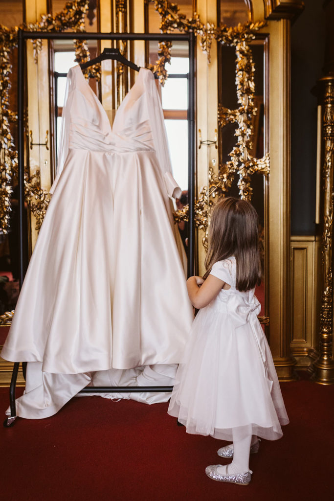 A flowergirl admires the wedding dress