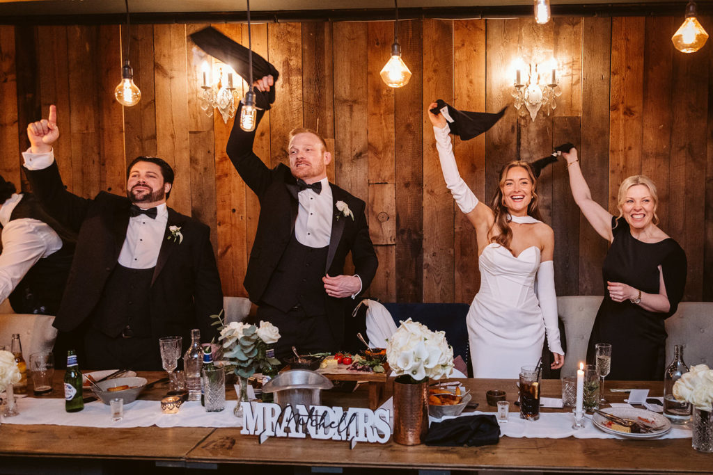 The bridal party wave their napkins in the air at this high energy wedding