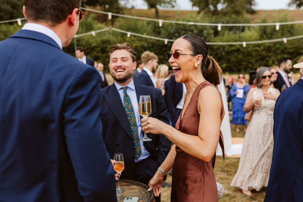 Wedding guests laughing during drinks reception