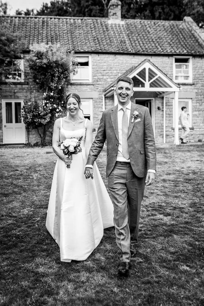Hester and Chris walking together in the grounds of their Oswaldkirk wedding