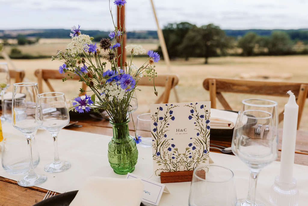 Wedding flowers and table decorations inside an Oswaldkirk marquee
