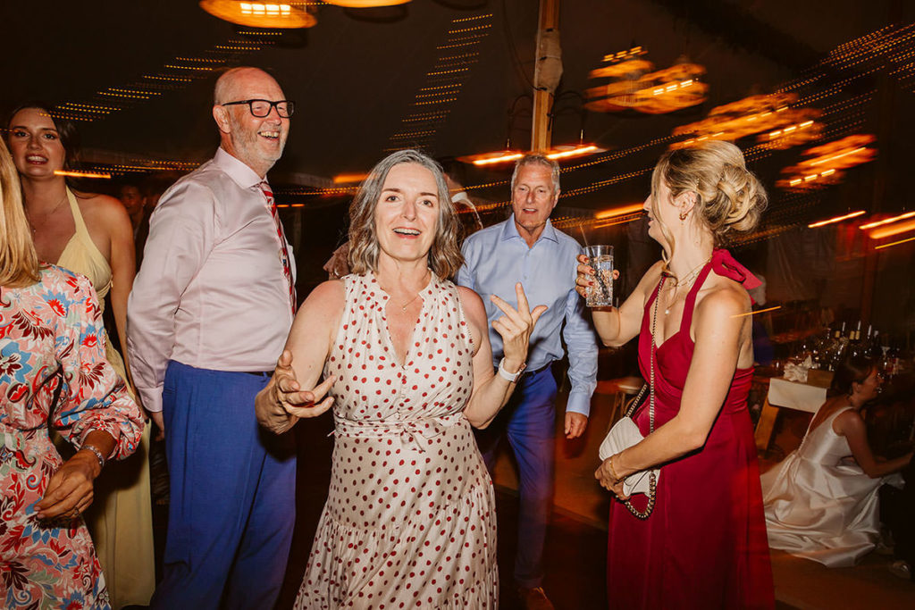 Wedding guests dancing inside a marquee in Oswaldkirk