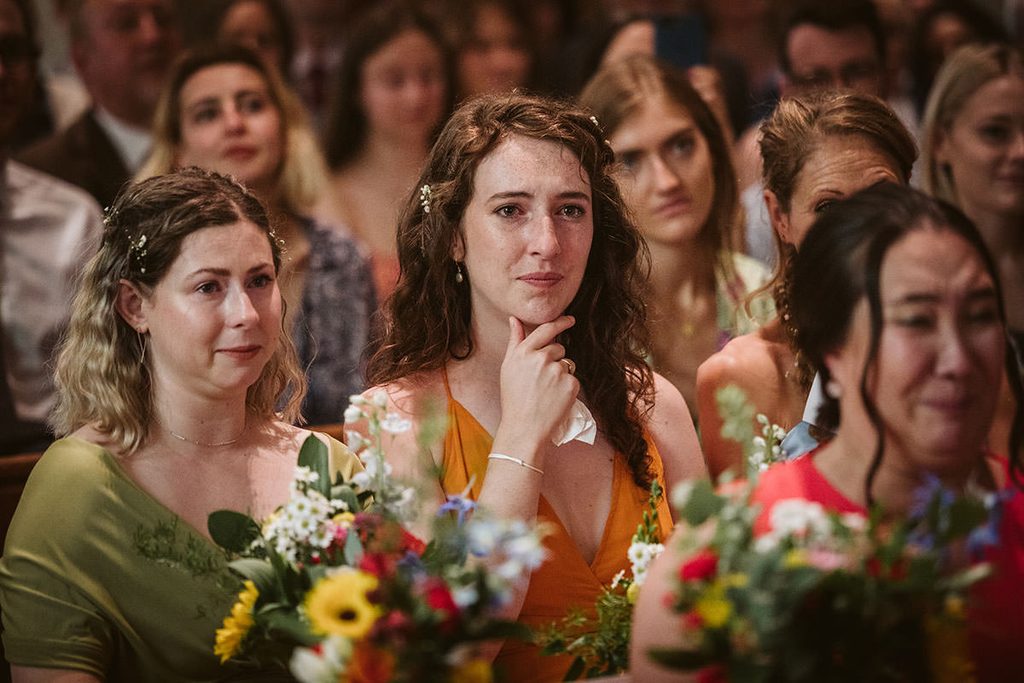Wedding guest wiping away a tear during the ceremony

