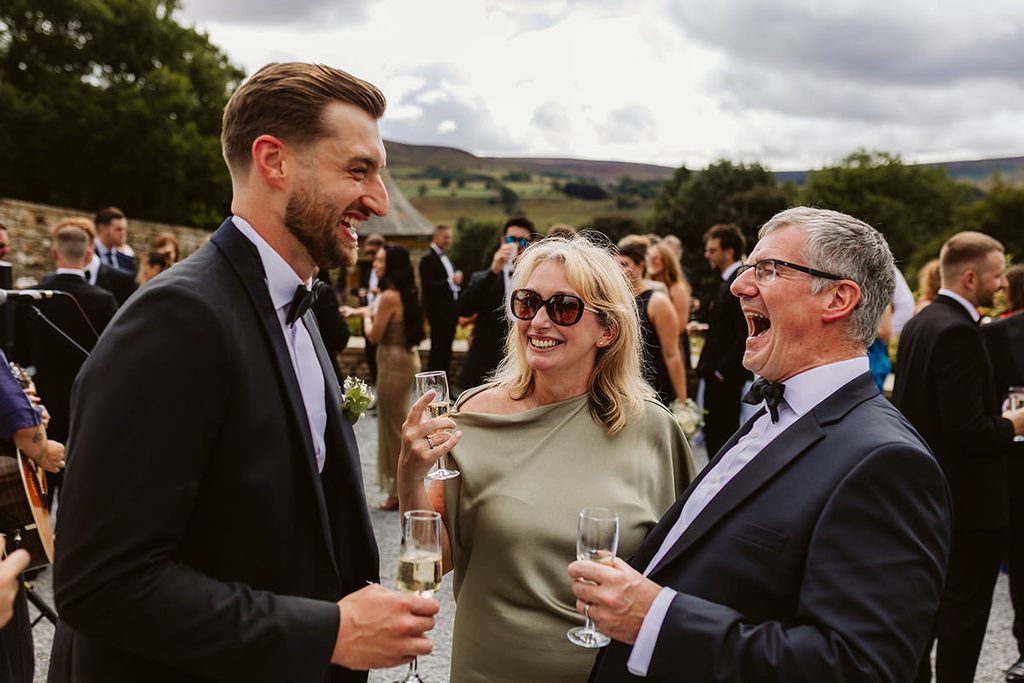 Wedding guests chatting and laughing in the garden at the Saddle Room

